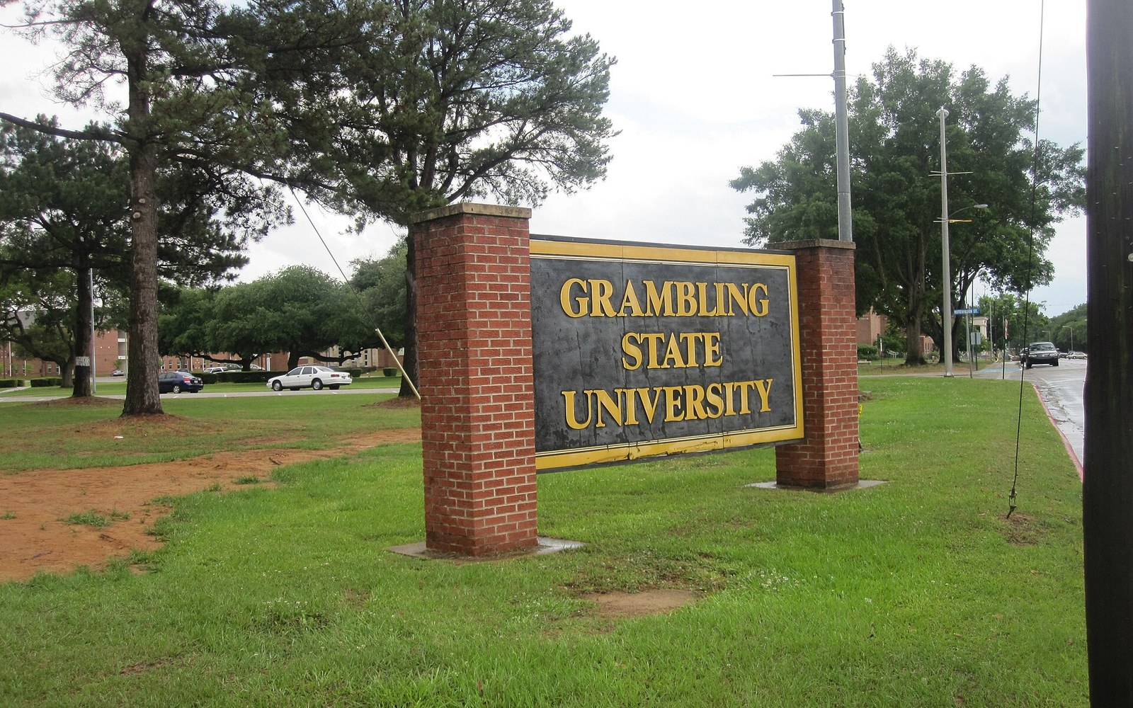Grambling State University entrance sign flanked by brick pillars on a grassy roadside